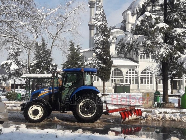 Akyazı'da muhtar ilçe merkezinde traktörle kar küredi