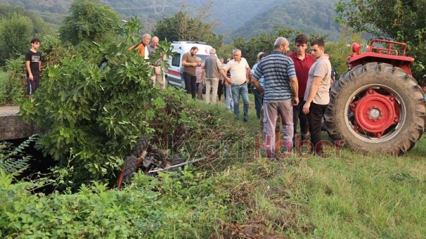 Dereye yuvarlanan traktörün altında kaldı